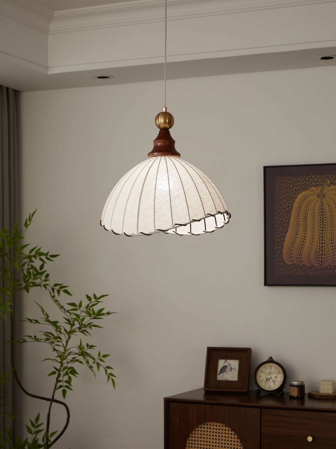 Modern pleated fabric pendant light with wood detail, enhancing interior design.