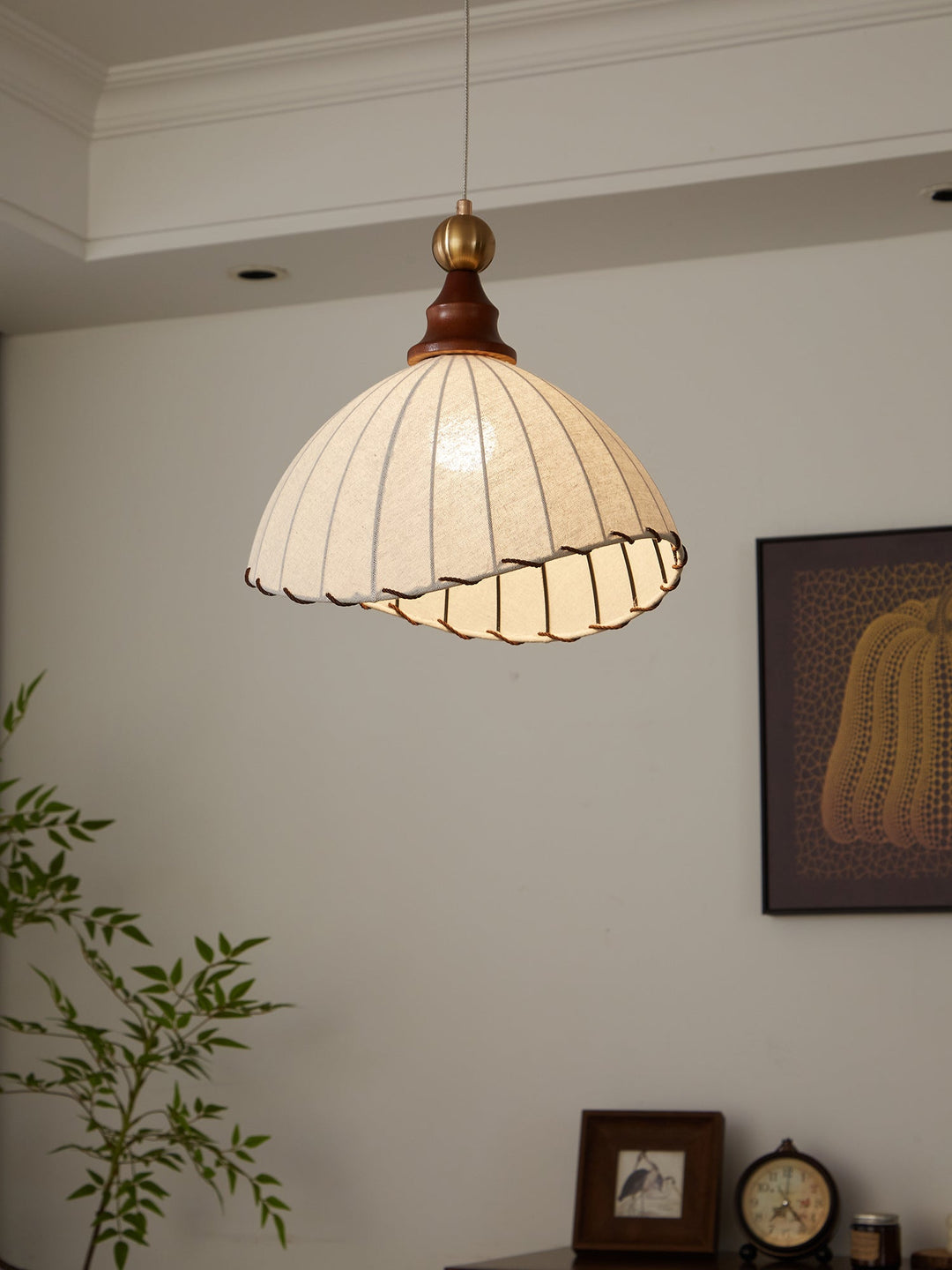 Pleated fabric modern pendant light, gold and wood accents, adjustable for living room.