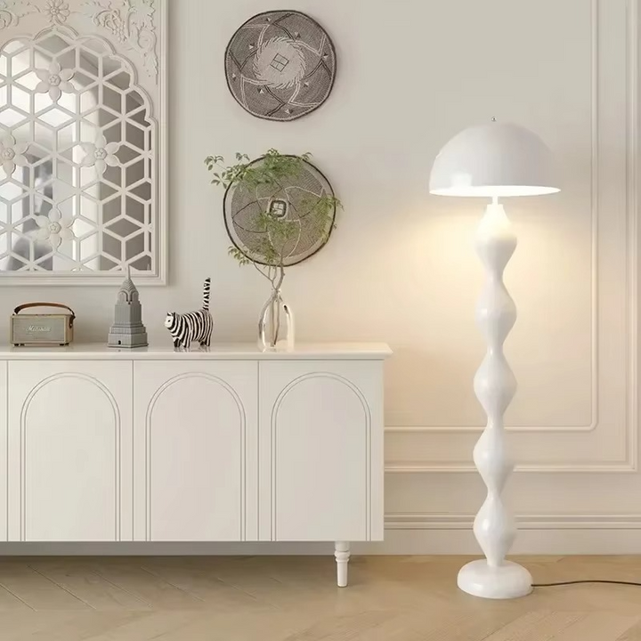 Tall standing floor lamp providing soft light, a modern Scandinavian design for cozy bedroom interiors.