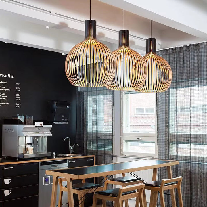 Natura Orb wooden pendant lamp hanging, casting soft natural light in a cozy interior setting.