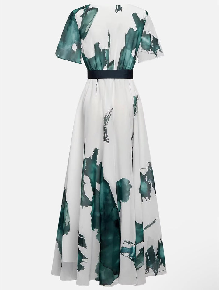 Close-up of a women's elegant long dress, showcasing its beautiful watercolor print and flowing texture.