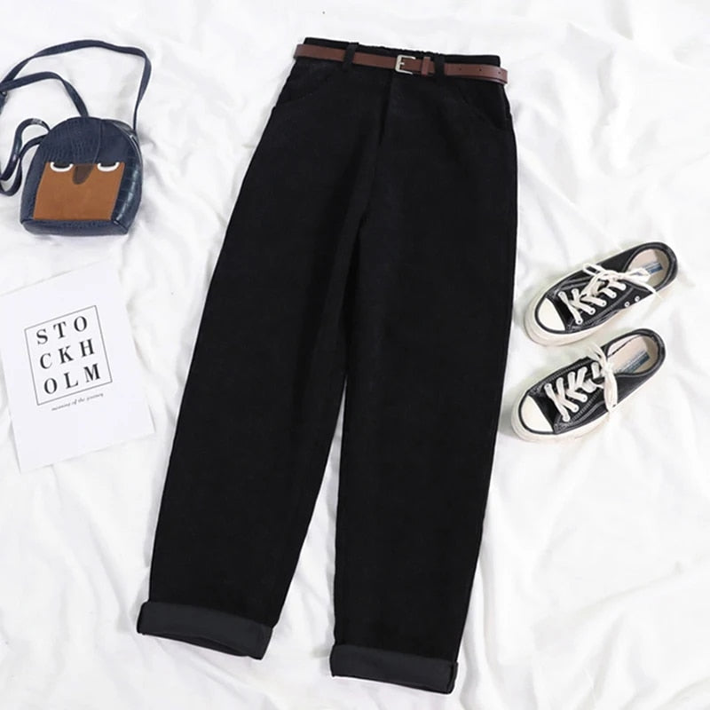 Close-up of the corduroy fabric texture on new black women's high-waisted casual trousers.