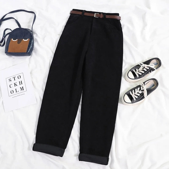Close-up of the corduroy fabric texture on new black women's high-waisted casual trousers.