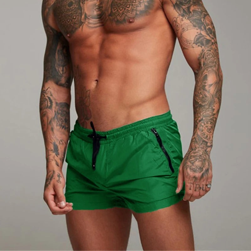 Closeup of men's quick-dry swim shorts, showing stretchy material and vibrant beachwear color.