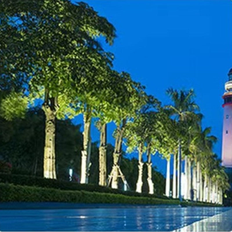 "Outdoor LED spotlights softly lighting tree bases with warm white glow, enhancing garden aesthetics with elegant aluminum de