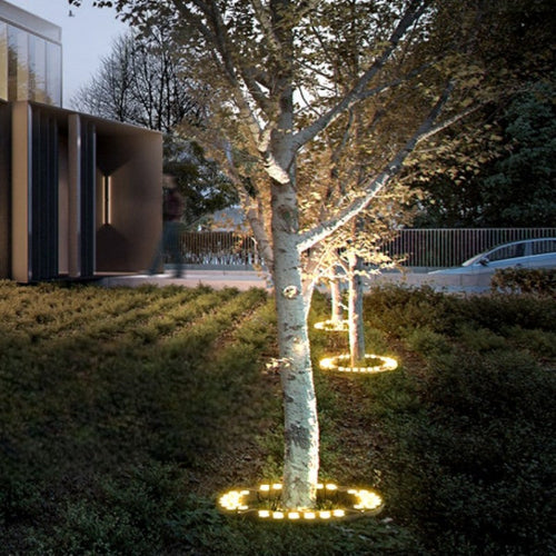"Outdoor LED spotlights softly lighting tree bases with warm white glow, enhancing garden aesthetics with elegant aluminum de