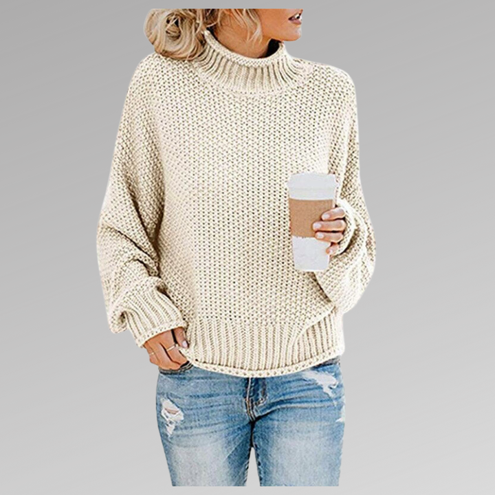 Woman wearing a light-colored oversized chunky knit sweater with jeans