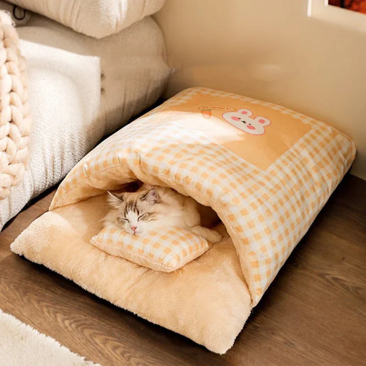 Adorable cat enjoying a deep nap in a warm, plush sleeping bag pet bed. Super cozy feline comfort.