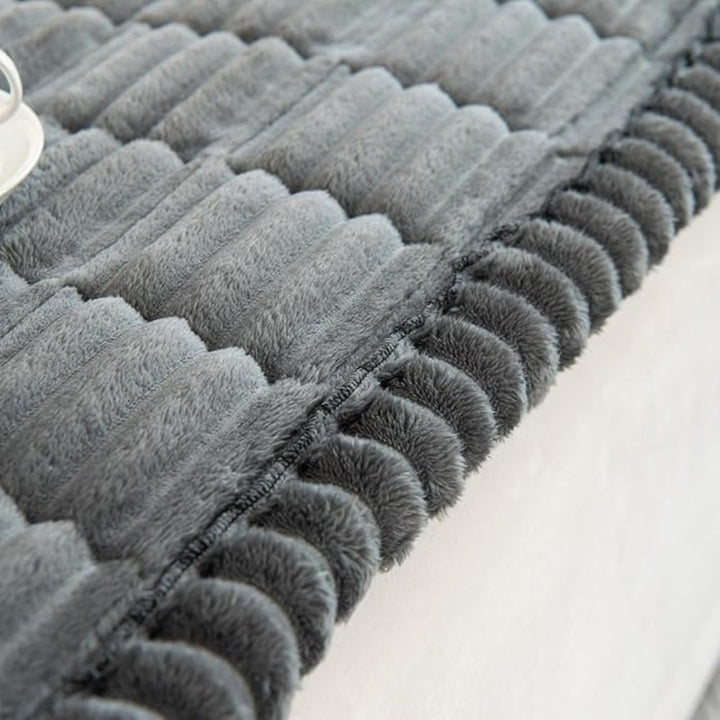 Durable quilted plush sofa protector mat, soft fleece, non-slip design for long-lasting furniture care.