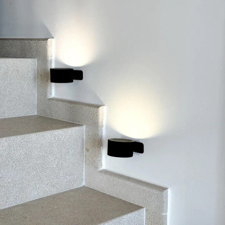 Minimalist cordless wall light, adjustable for reading or accent lighting in modern living spaces.