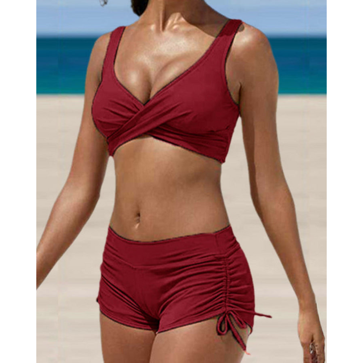 Model in a black high-waisted two-piece bikini, emphasizing shaping and support for beachwear.