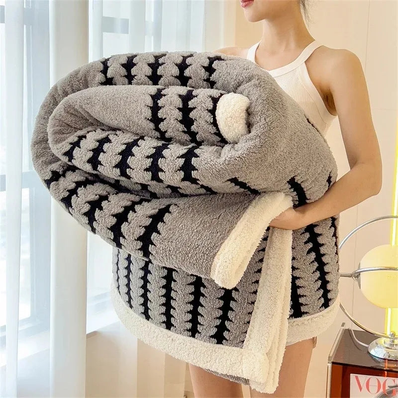 Reversible geometric throw blanket; one side with design, other soft sherpa fleece. Warm home decor.