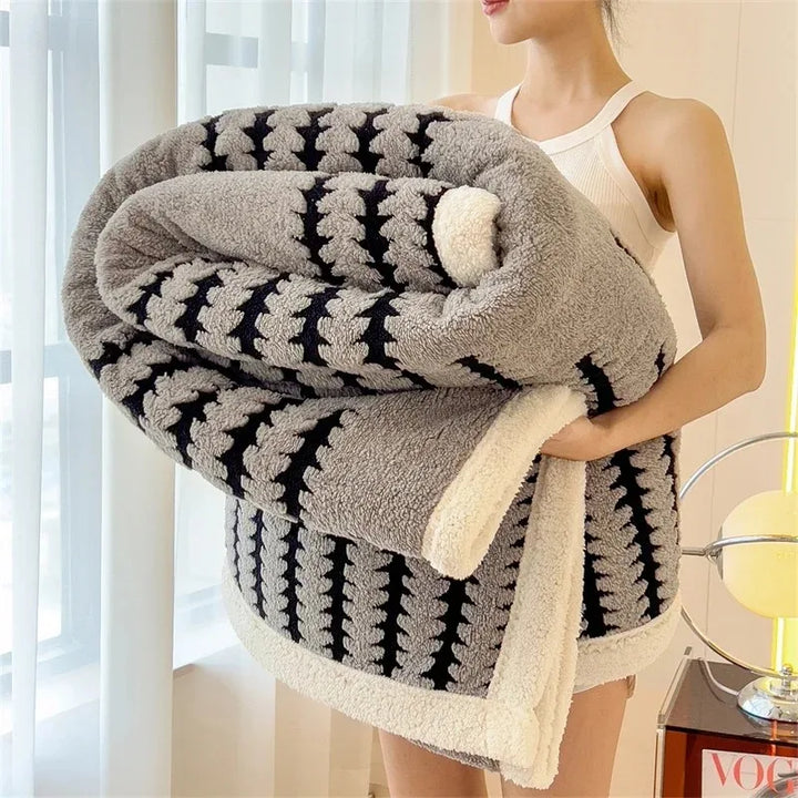 Reversible geometric throw blanket; one side with design, other soft sherpa fleece. Warm home decor.
