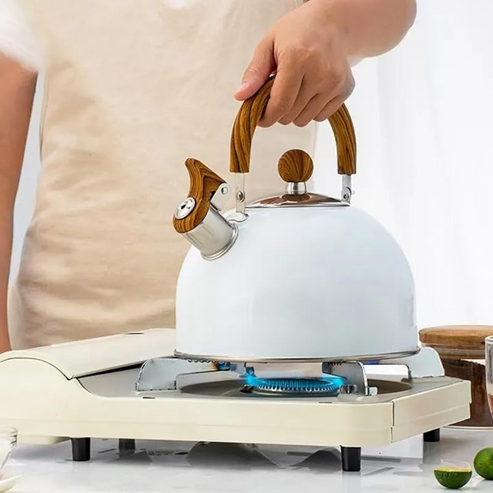 Modern whistling tea kettle made of stainless steel, perfect for boiling water on any stove top.