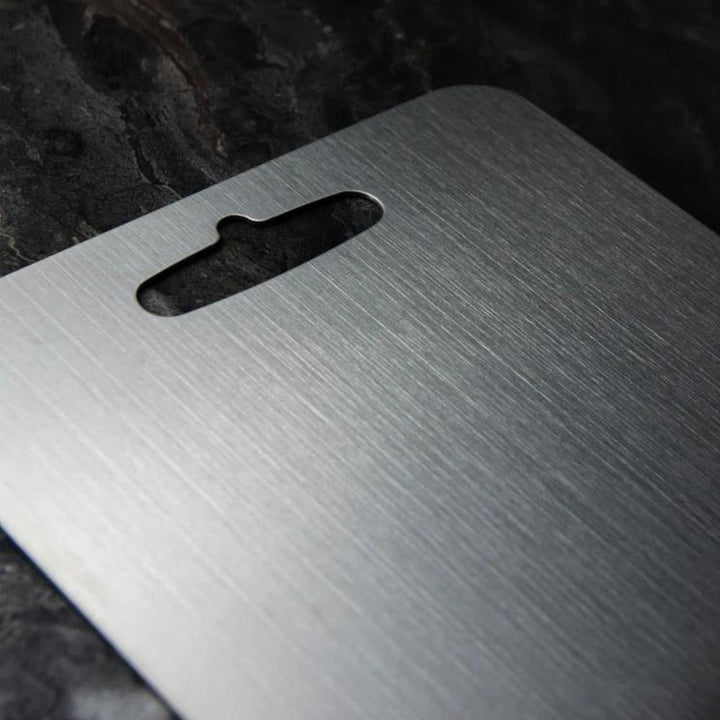 Durable silver stainless steel kitchen cutting board, ideal for food prep and chopping tasks