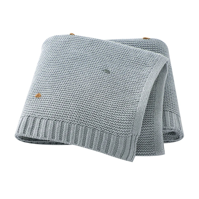 Close-up of a cozy, unisex knitted cotton baby blanket, ideal for newborns & infants. A soft, all-season nursery essential.