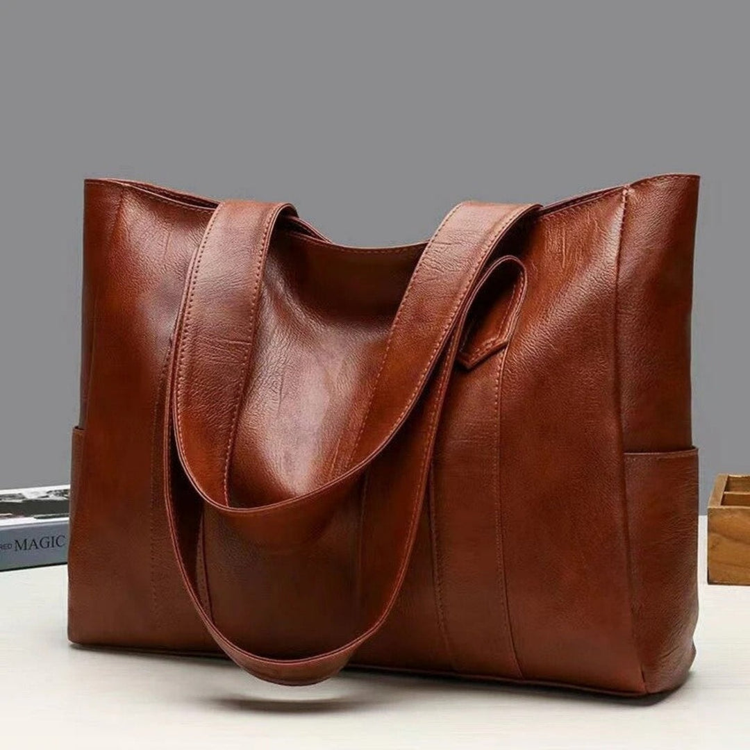 Stylish brown faux leather women's shoulder tote bag with ample space & interior pockets, ideal for daily use.