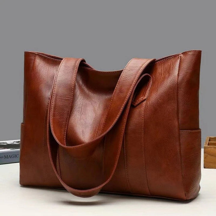 Stylish brown faux leather women's shoulder tote bag with ample space & interior pockets, ideal for daily use.