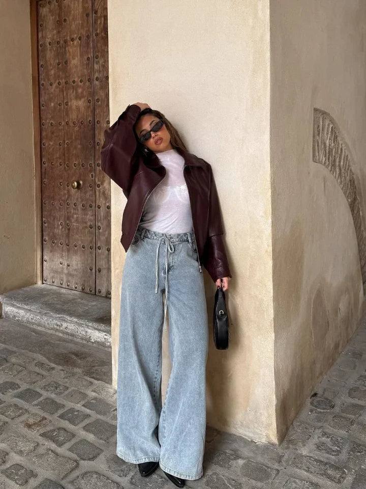 Modern women's oversized waist-length leather jacket, a versatile zip-up outerwear choice for chic autumn fashion.