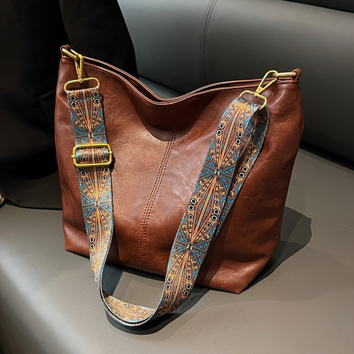 Stylish women's tote bag with elegant design, decorated straps, and spacious interior. Perfect fashion accessory.