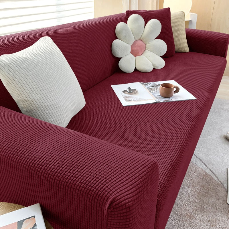 Textured stretch sofa cover with easy-care features, shown being placed on a couch