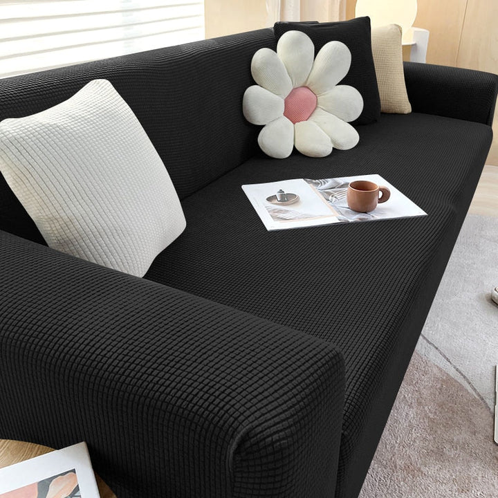 Non-slip textured sofa cover fitting snugly on a three-seater sofa, enhancing decor