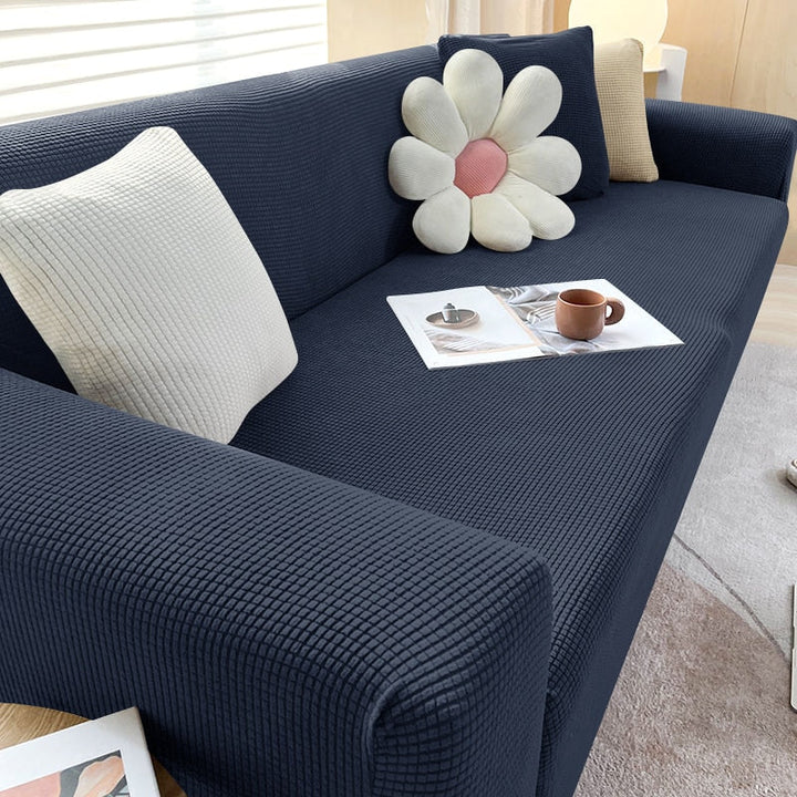 Pet-friendly textured stretch sofa cover, durable and easy to clean, draped over a couch