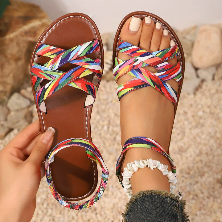 Model wearing stylish unisex handmade strappy sandals on a sandy beach, perfect for summer