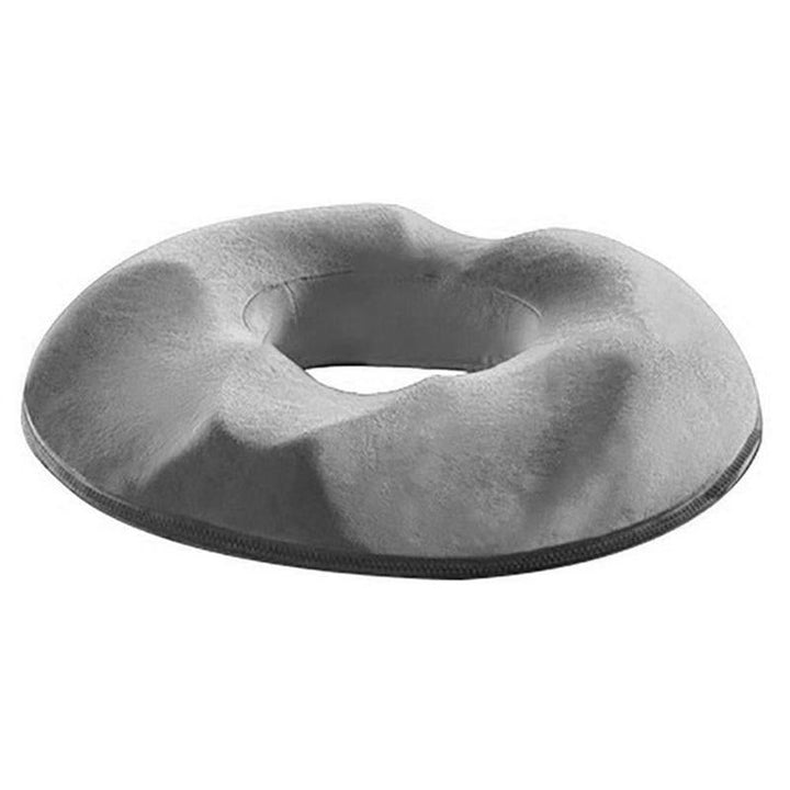 Person comfortably sitting on a memory foam coccyx & hemorrhoid relief cushion, reducing pain & pressure.
