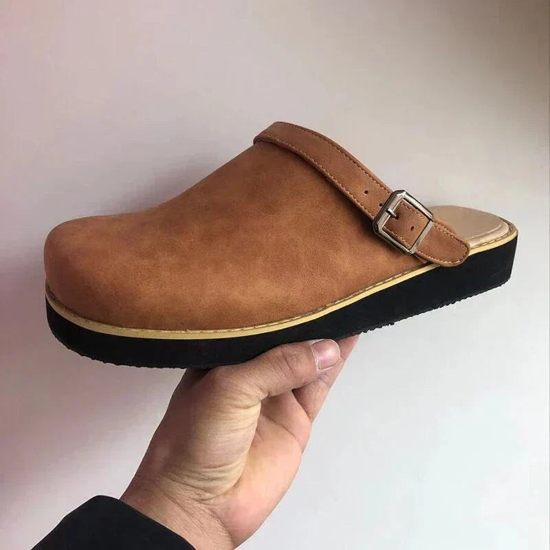 Close-up of durable black leather orthopaedic clogs, slip-on design, supportive sole