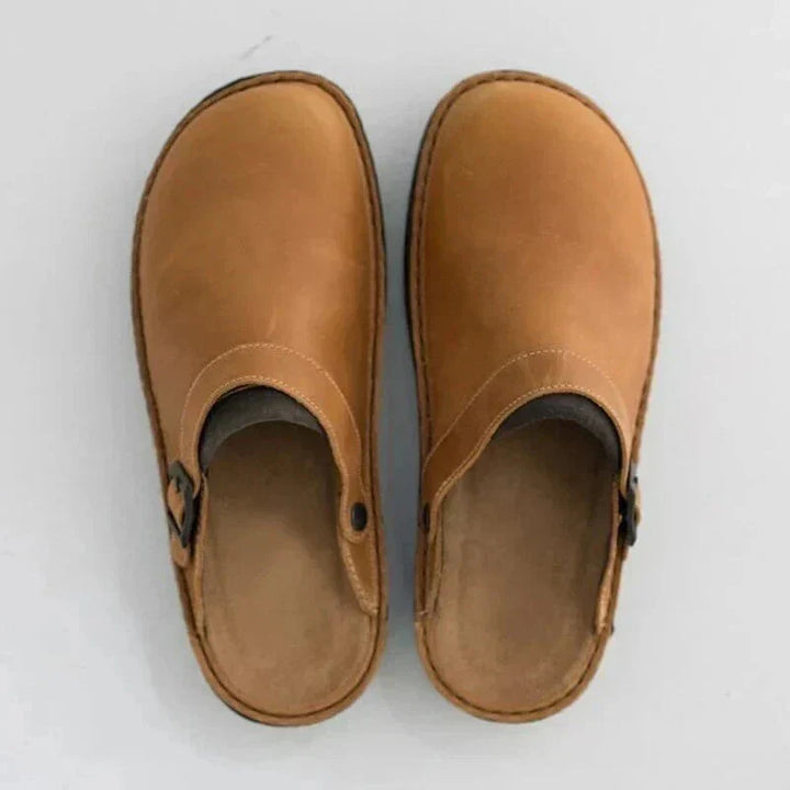 Pair of unisex tan leather orthopaedic clogs on a white background, casual comfort footwear