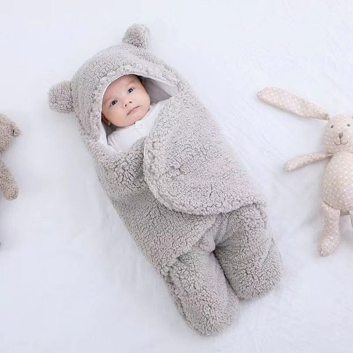 Newborn ultra-soft quilted baby swaddle with adorable bear ears. Plush and cozy infant sleepsack for warmth.