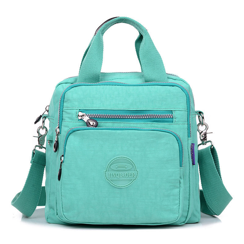 Unisex water-resistant crossbody bag, perfect blend of fashion and function, laid flat to show all features.