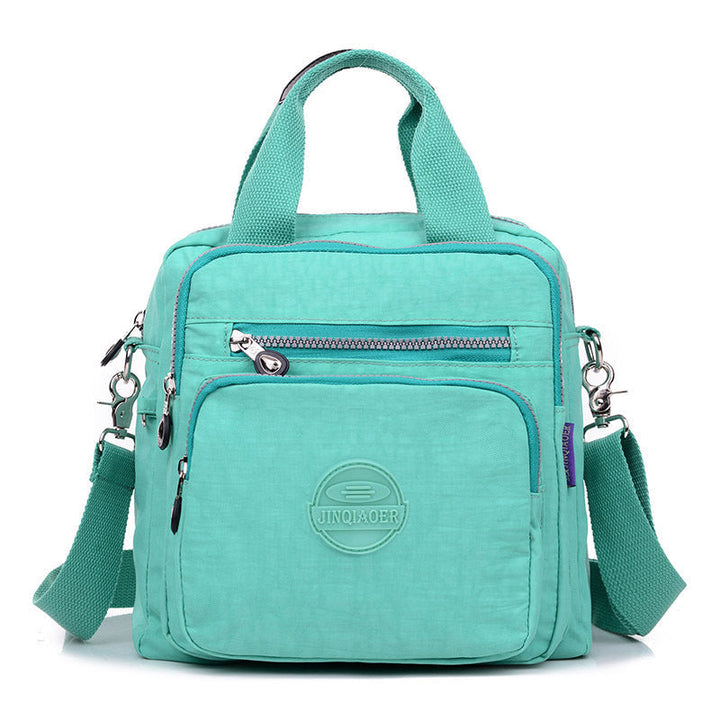 Unisex water-resistant crossbody bag, perfect blend of fashion and function, laid flat to show all features.