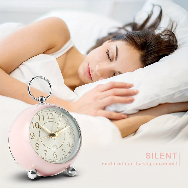 Quiet vintage analog alarm clock, round shape, clearly readable, with a soft night light.