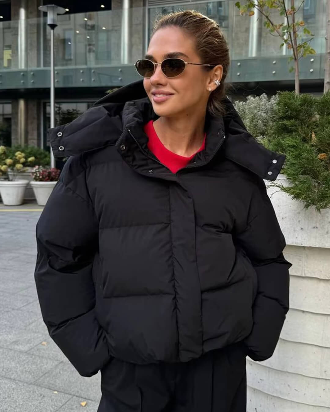 Closeup of a women's puffer jacket with hood, showcasing its cozy winter outerwear fabric.