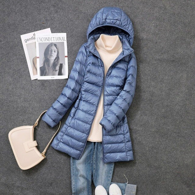 Front view of a women's long black puffer jacket with a zip closure and a cozy detachable hood