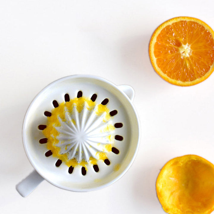 White ceramic kitchen tool, a reliable manual citrus juicer for making healthy fresh fruit drinks.