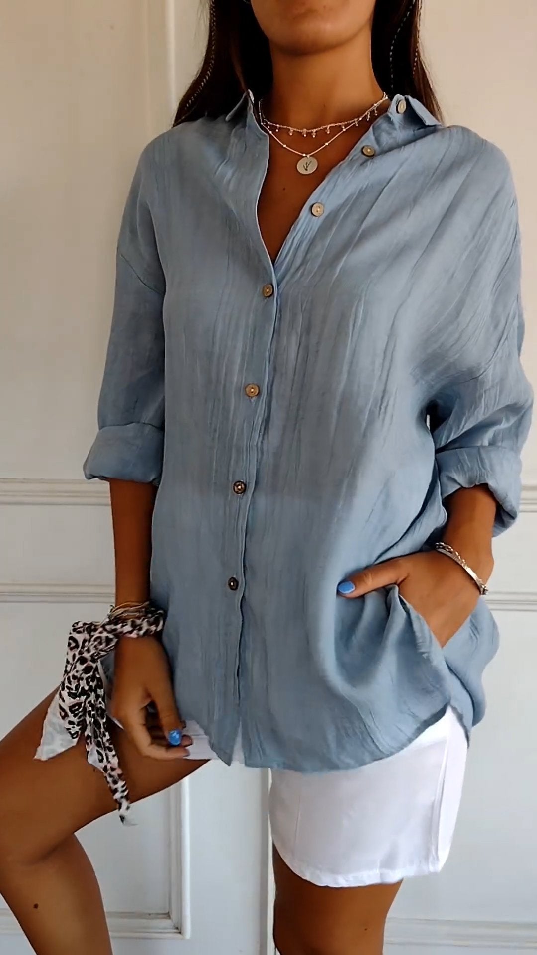 Flat lay of a white cotton blend long sleeve button-down shirt, a staple for women's casual wear.