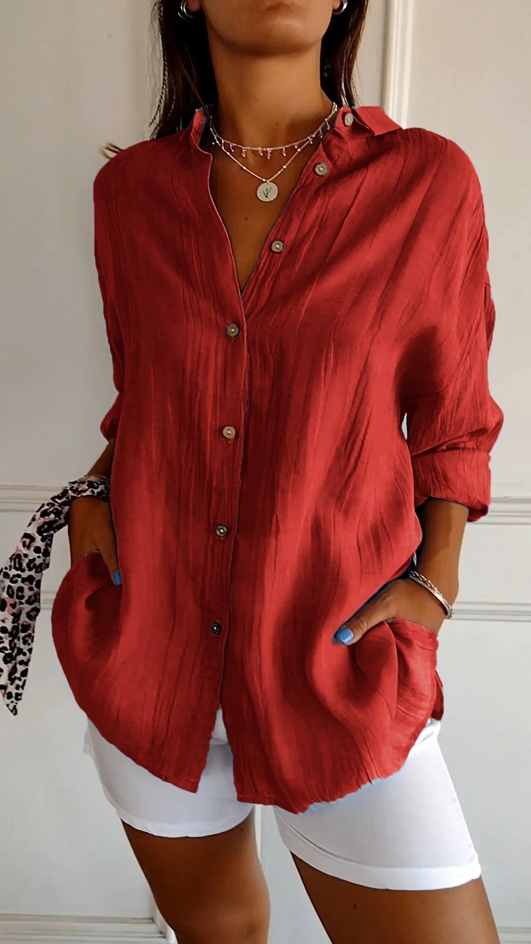 Front view of a women's white casual button-down shirt with long sleeves, made from cotton blend.