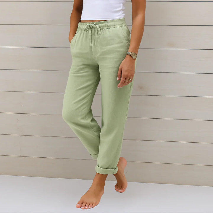 Pair of women's linen blend stretch trousers, folded neatly, showcasing the comfortable and breathable fabric.