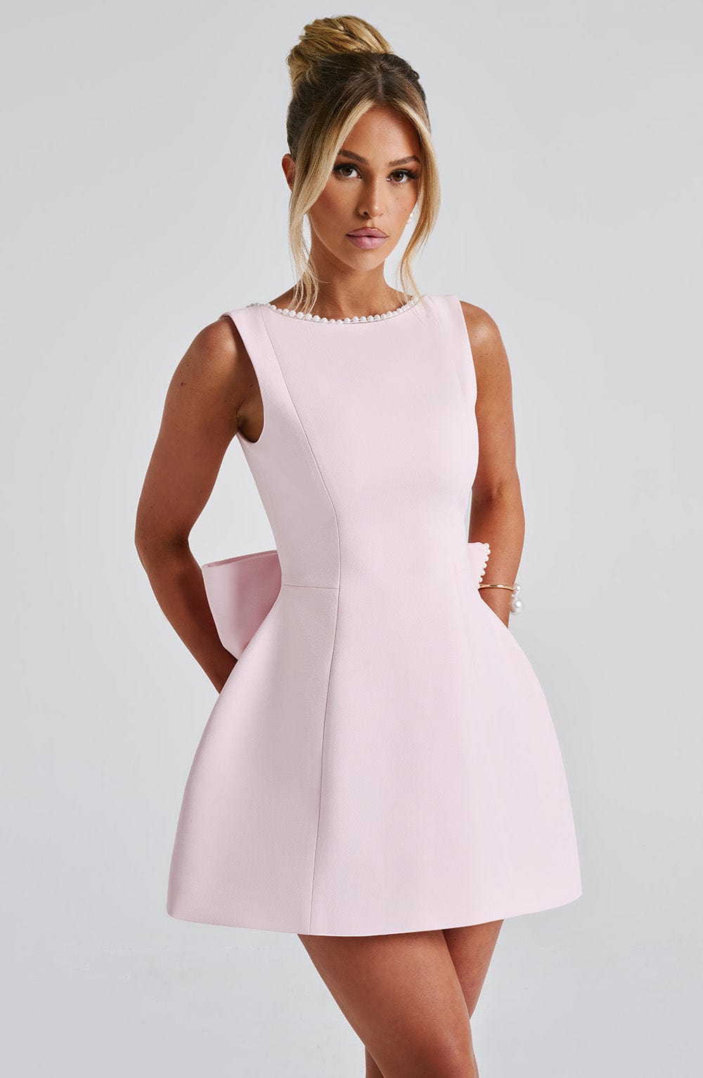 Elegant sleeveless A-line mini dress for women, delicate pearl trim. Ideal wedding guest & party wear.
