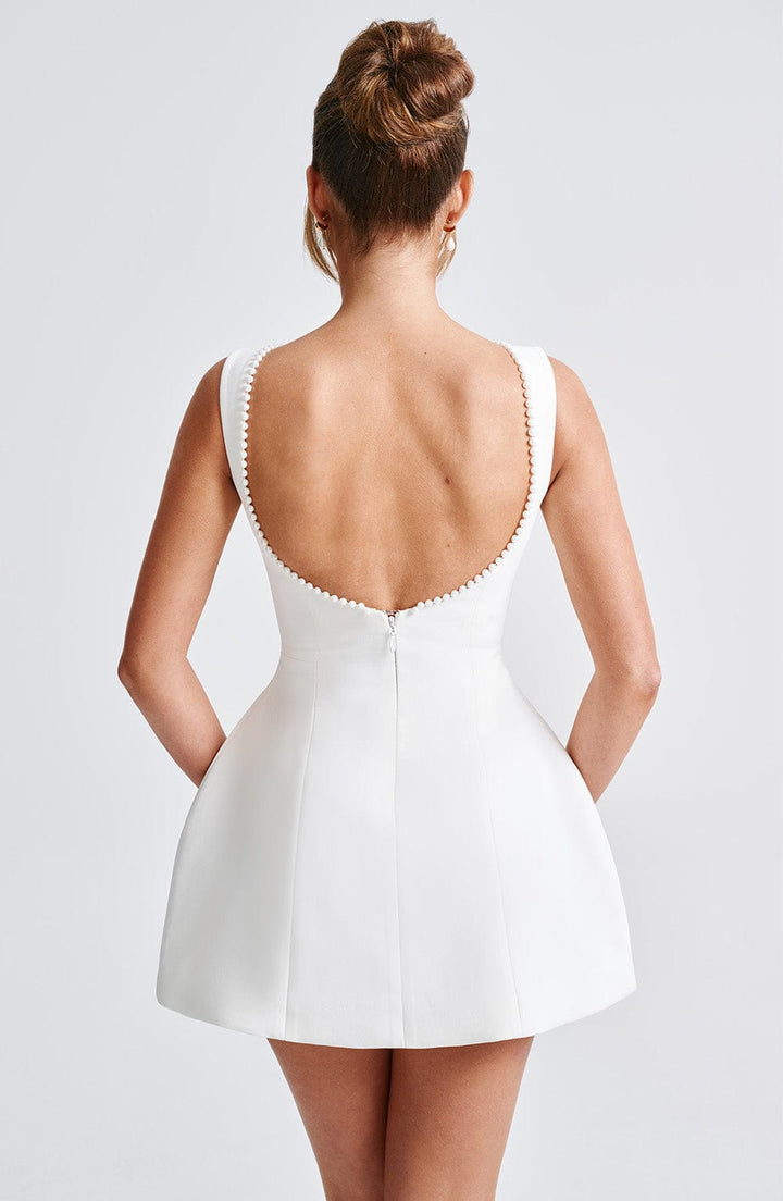Elegant back view of a women's A-line mini dress, showcasing pearl trim. Perfect for wedding guests.