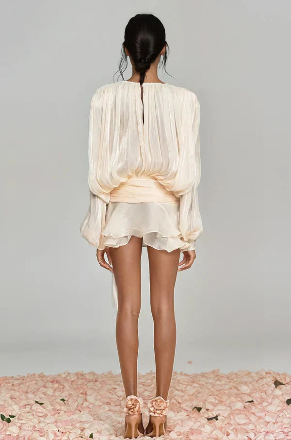 Close-up of the textured fabric and intricate ruffles on a women's balloon sleeve cocktail dress