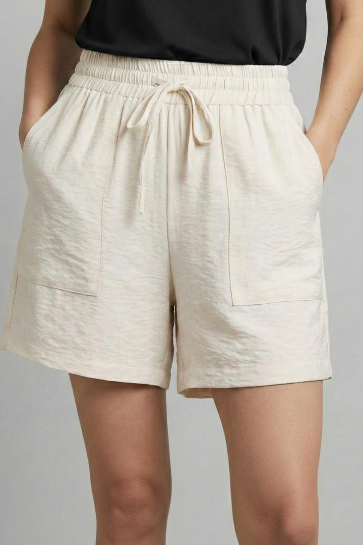 Model demonstrating the versatility of women's white casual drawstring shorts, great for warm weather fashion