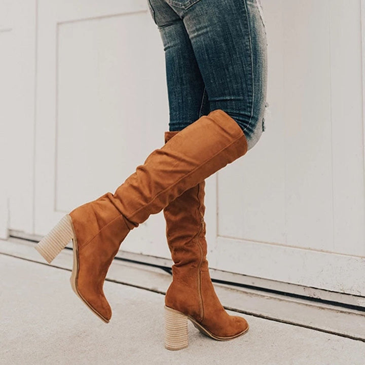 Close-up of a women's tan thigh-high boot featuring a comfortable chunky heel and over-the-knee design