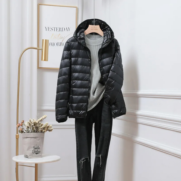 Close-up of a women's silver hooded zip puffer jacket fabric, highlighting its warmth