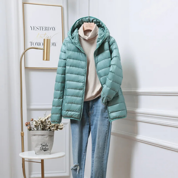 Front view of a women's green hooded zip puffer jacket with pockets, warm & casual