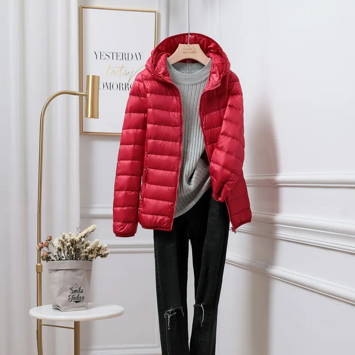 Casual women's black hooded zip puffer jacket paired with jeans, essential winter outerwear