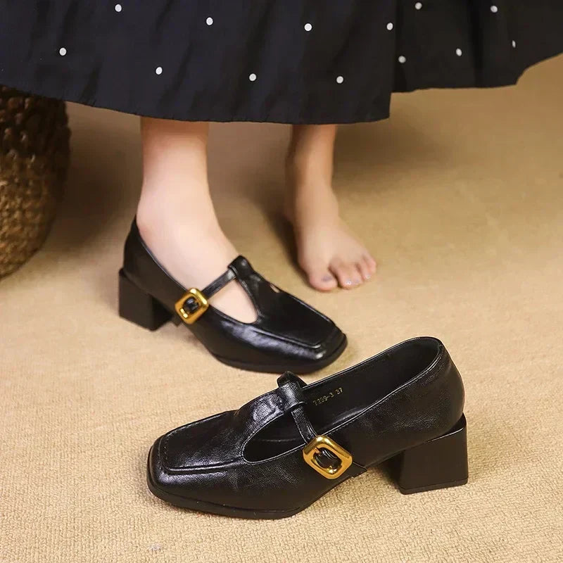 Elegant women's black Mary Janes, featuring a block heel, square toe, and sophisticated T-strap design.